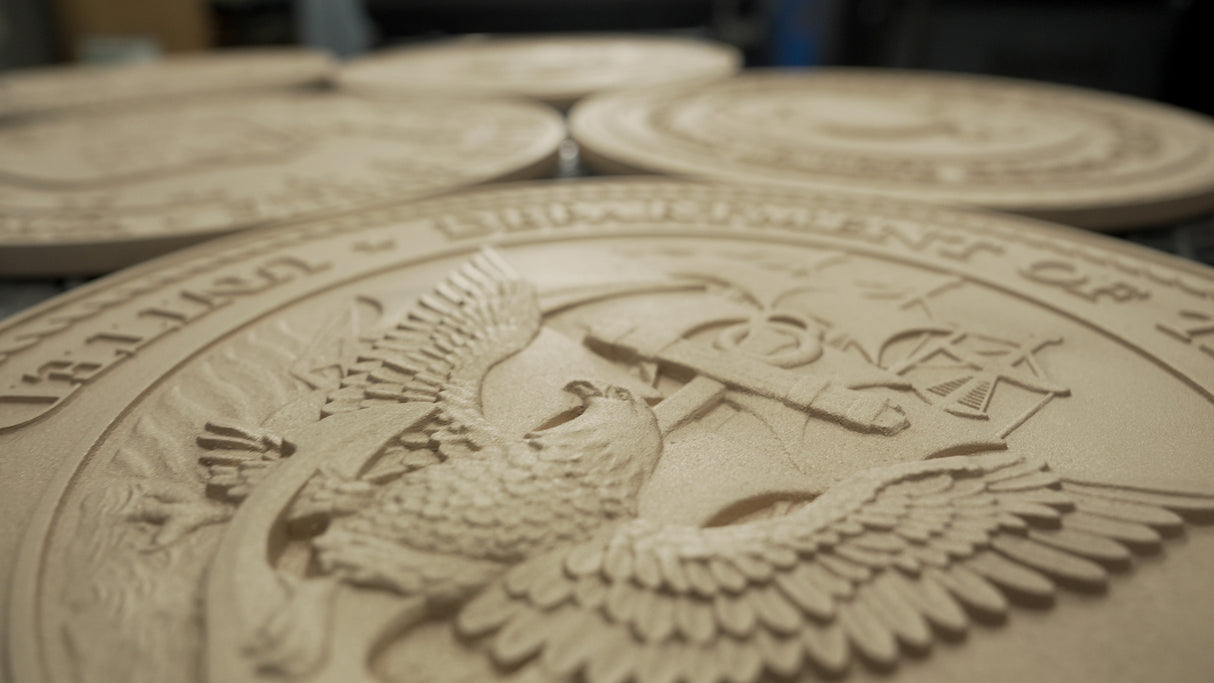 Closeup of cast metal military seals in production