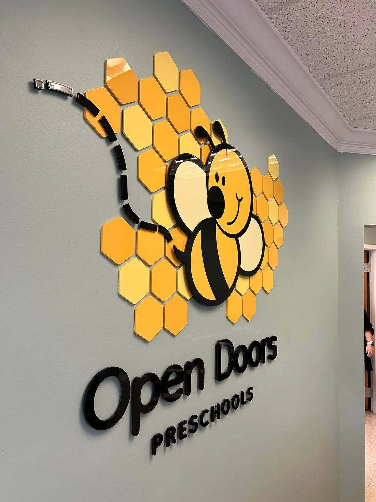 Flat cut acrylic preschool sign with black letters and a glossy sheen