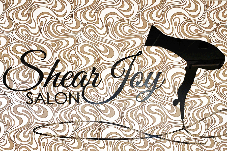 Hair salon sign with black acrylic sign letters and shapes.