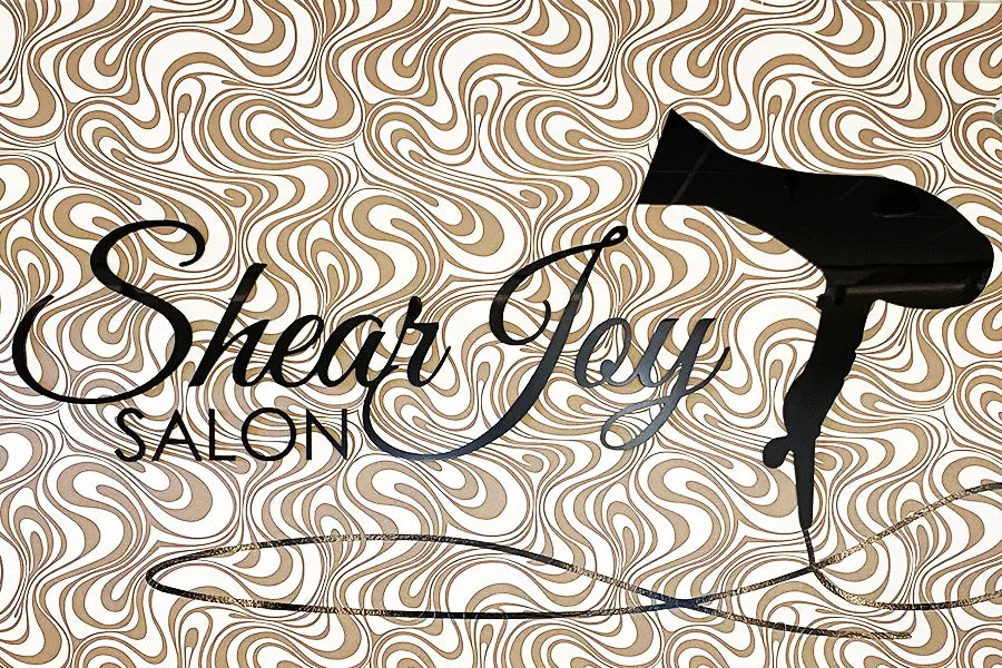 Hair salon sign with black acrylic sign letters and shapes.