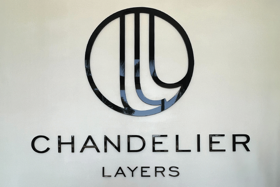 Lobby sign with unpainted black acrylic sign letters and shapes.