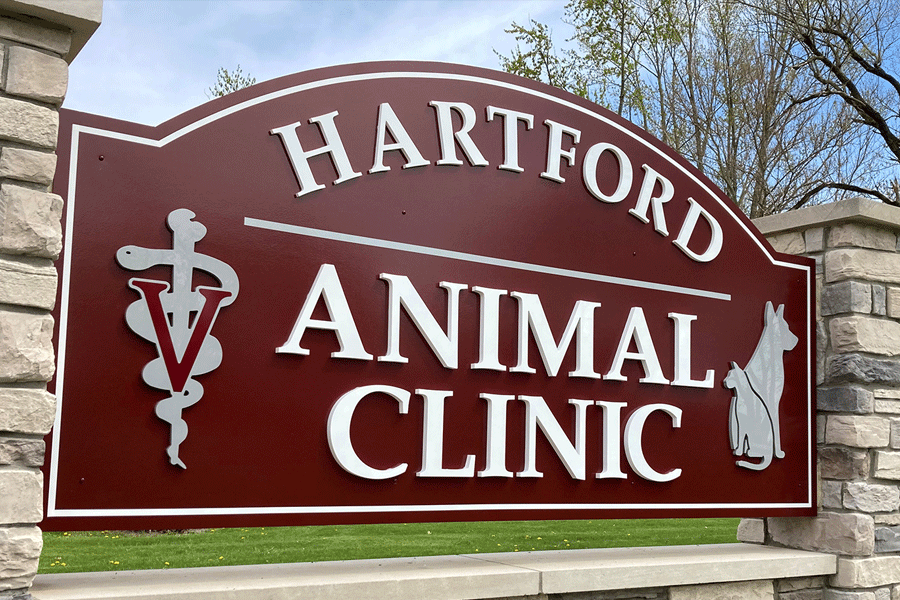Exterior veterinary sign with unpainted white acrylic sign letters and brushed aluminum sign elements.