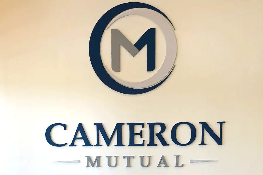 A lobby sign for Cameron Mutual Bank with blue and gray sign letters and a large acrylic M logo.