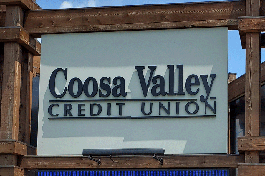 An exterior post and panel sign for Coosa Valley Credit Union with black flat cut acrylic sign letters on a white background.