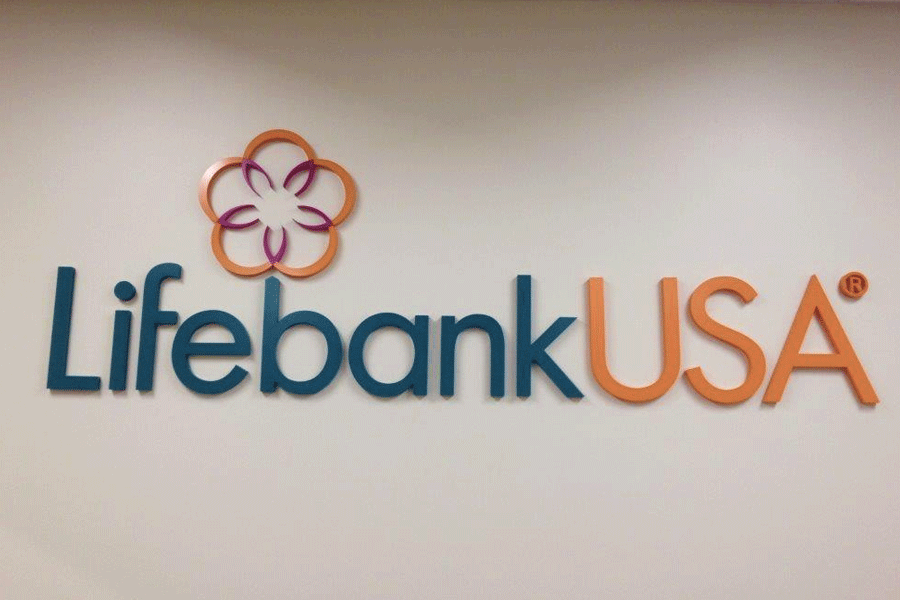 A bank lobby sign for LifebankUSA with a blue and orange sign letters and a flower logo.