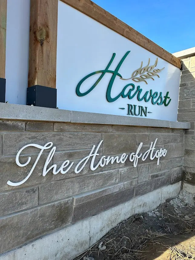 Monument sign with green and white painted aluminum sign letters