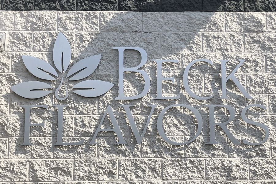 An exterior building sign with brushed aluminum sign letters and shapes.