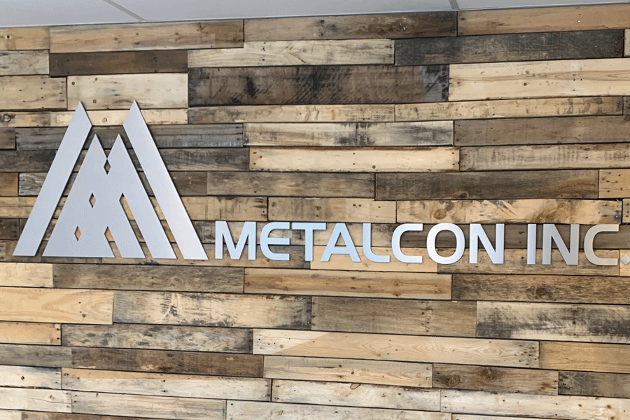 An interior business sign with brushed aluminum sign letters and shapes.