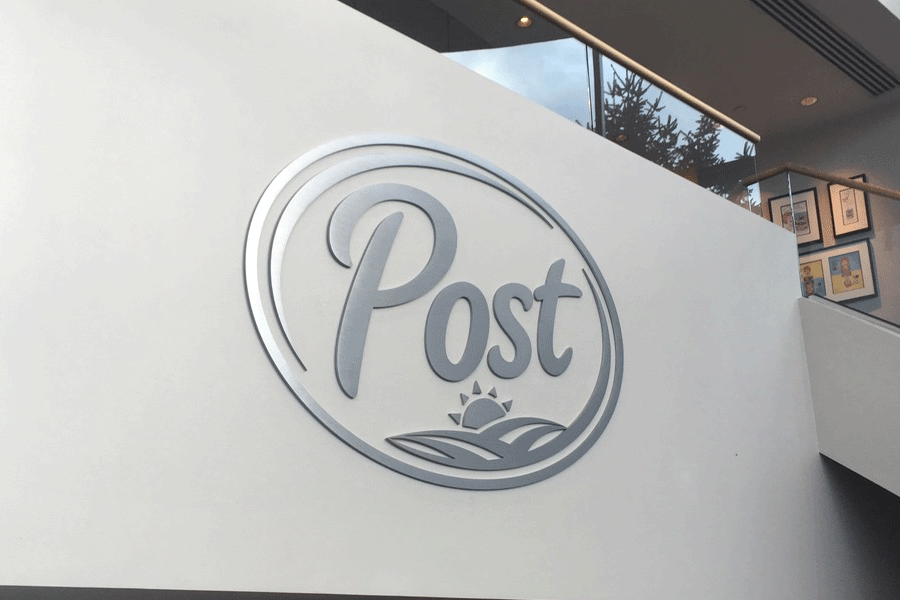 An interior wall sign of the Post logo with brushed aluminum sign letters and shapes.