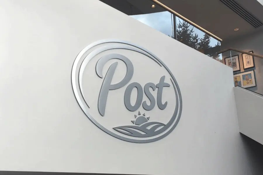 An interior wall sign of the Post logo with brushed aluminum sign letters and shapes.