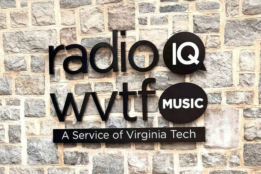 An exterior building sign for a radio station with black anodized aluminum sign letters.