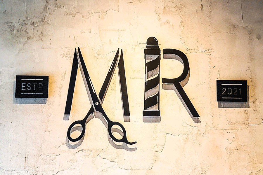A barbershop lobby sign with black anodized aluminum sign letters and shapes.