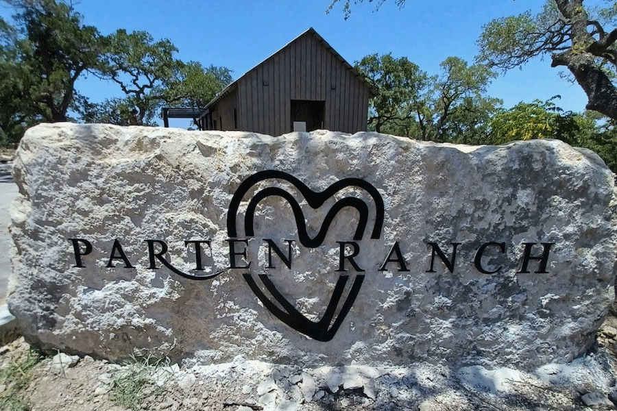 An exterior monument sign for a ranch with black anodized aluminum sign letters and shapes.