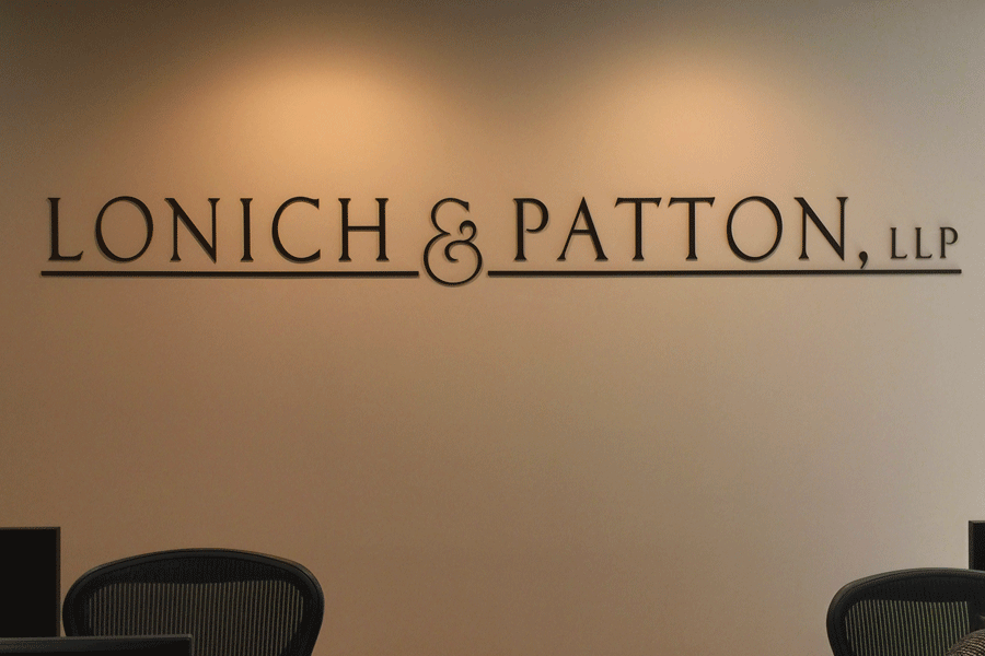 An interior lobby sign for a law office with dark bronze anodized aluminum sign letters.