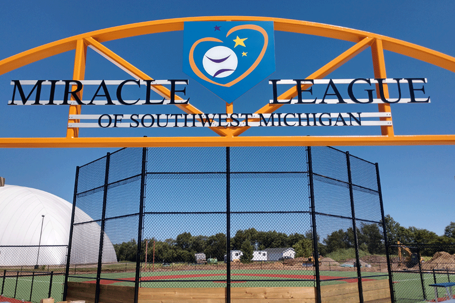 A baseball park sign with a painted aluminum logo and black aluminum sign letters.