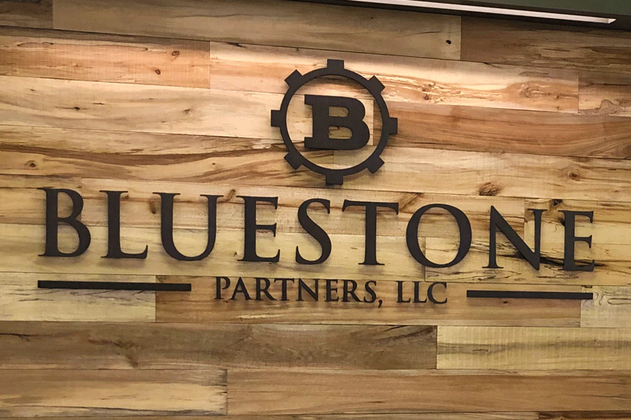 A weathered steel lobby sign for Bluestone Partners LLC.