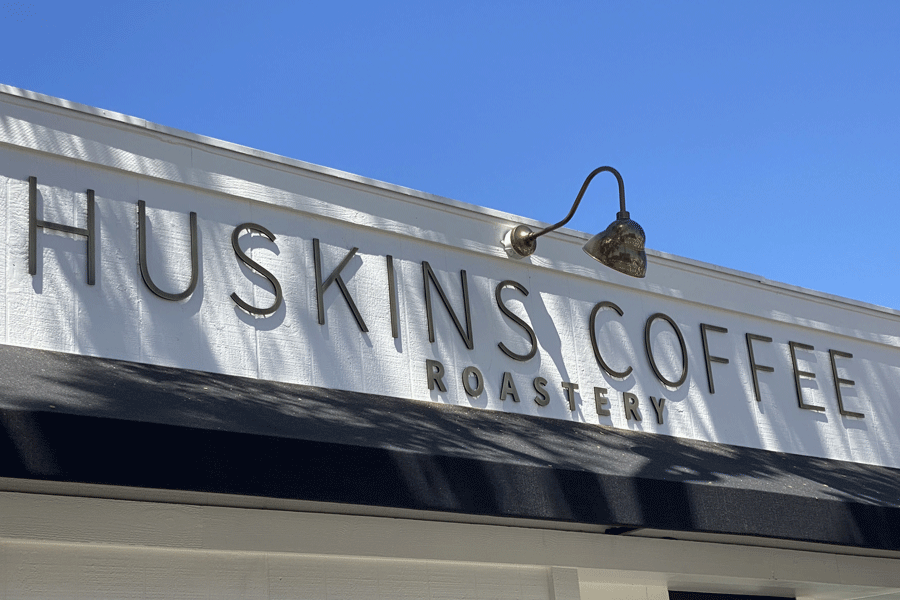 A coffee shop sign with aged bronze sign letters.