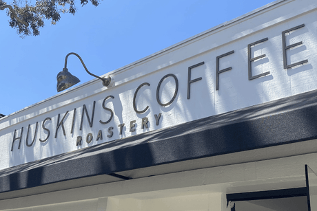 A coffee shop sign with aged bronze sign letters.