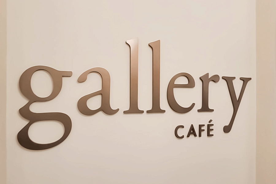 Cafe sign with aged brass or bronze sign letters.