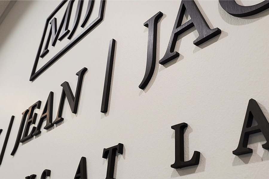 Law firm sign with aged bronze sign letters and shapes.