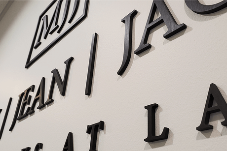 Law firm sign with aged bronze sign letters and shapes.