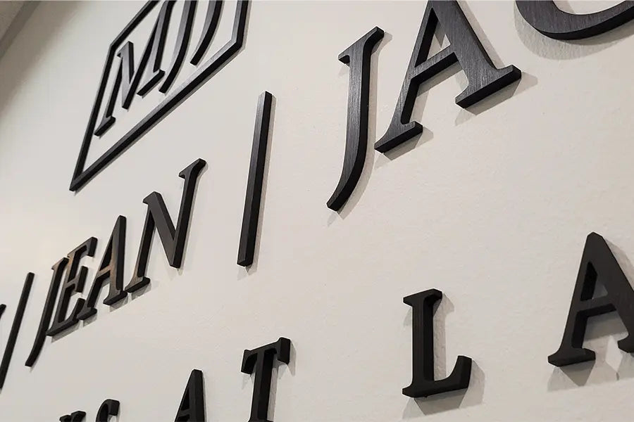 Law firm sign with aged bronze sign letters and shapes.