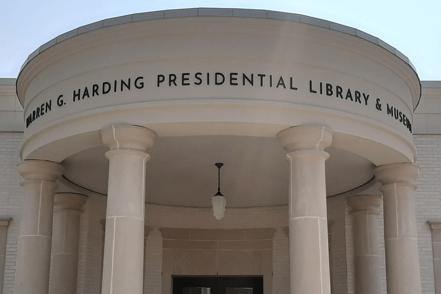 Library and museum sign with aged bronze sign letters.