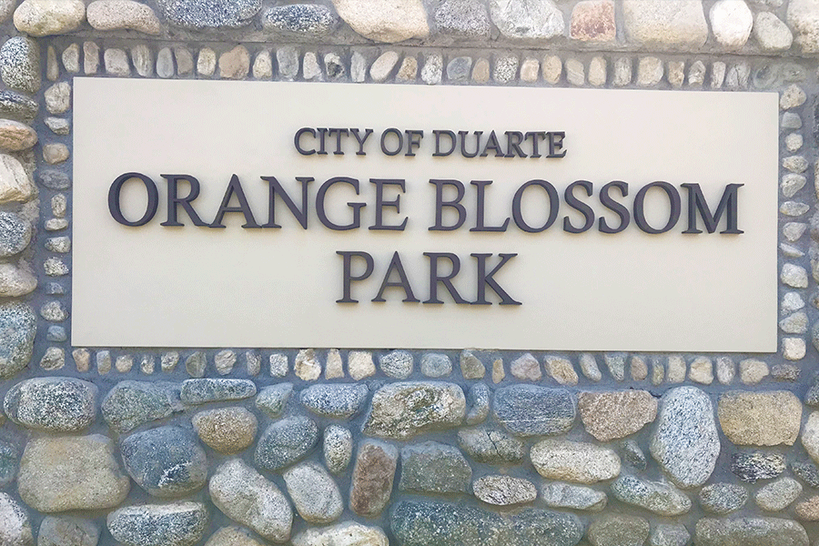 Monument sign for a city park with aged bronze sign letters.