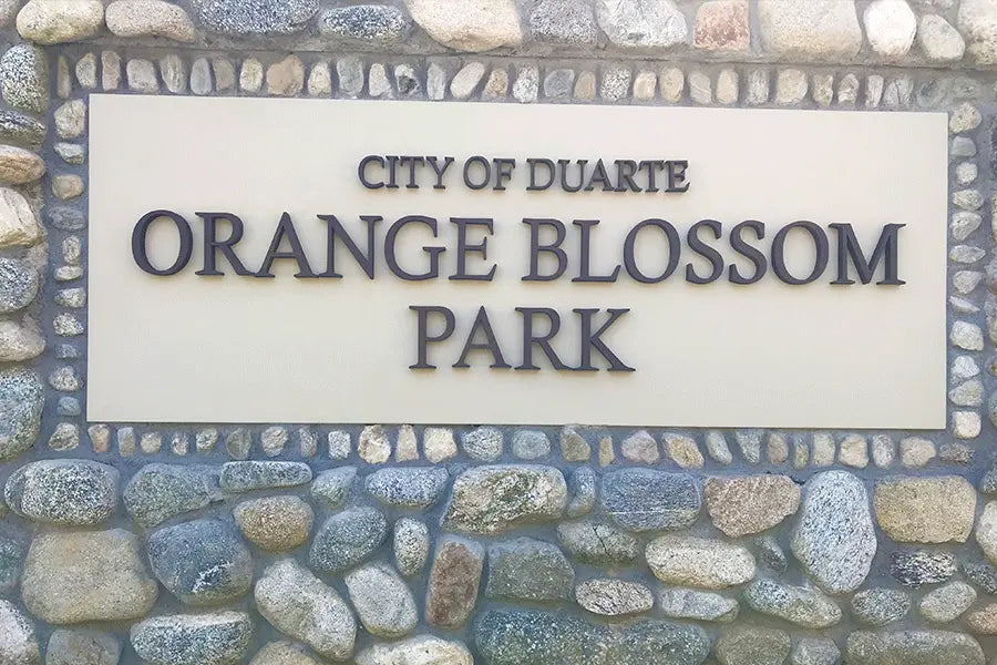 Monument sign for a city park with aged bronze sign letters.