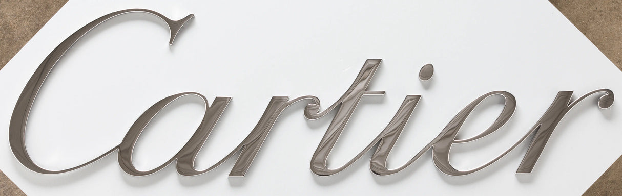 A storefront sign with polished bronze sign letters.