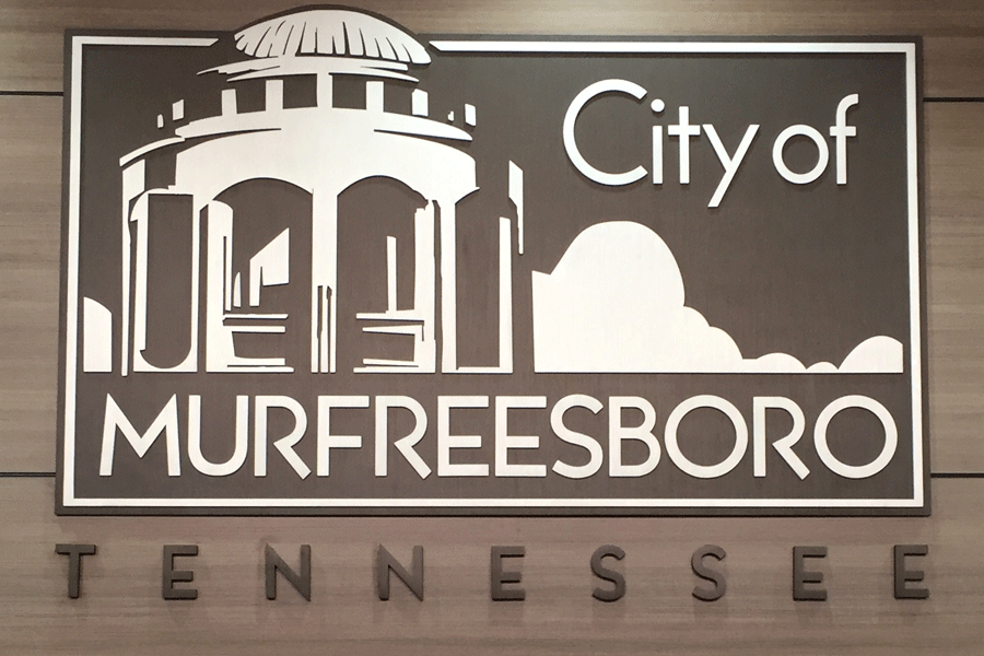 A municipal city sign with aged bronze sign letters and hapes.