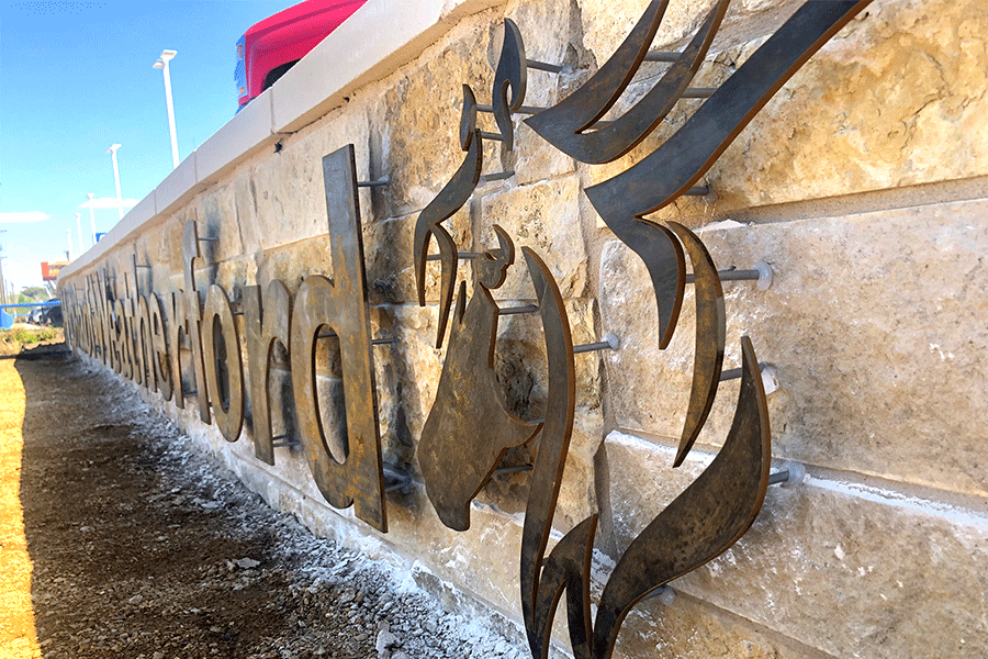 Exterior monument sign with weathered steel sign letters and logo.