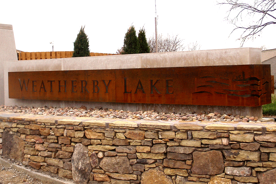 Monument sign of weathered steel with letter cutouts.