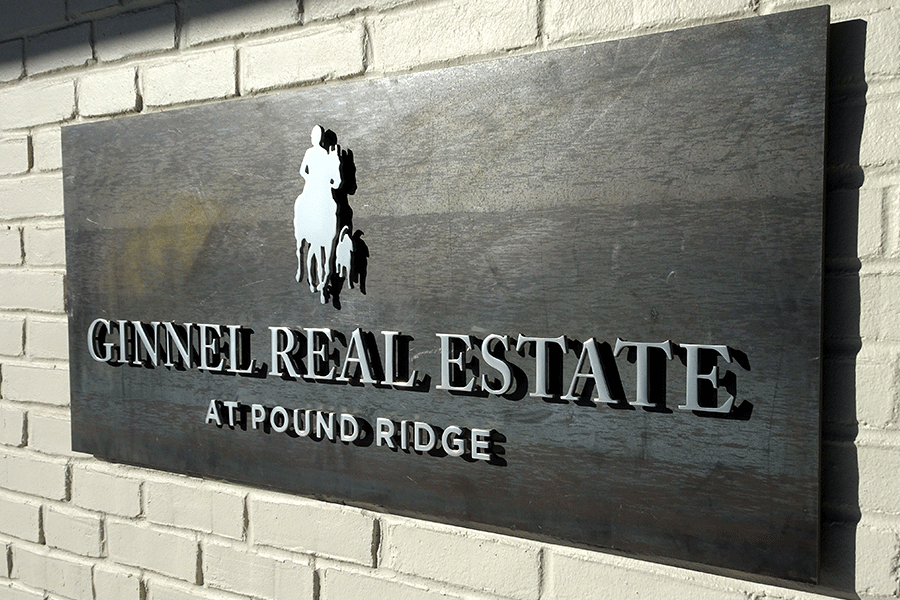 Residential development sign with stainless steel sign letters on a weathered steel plate.