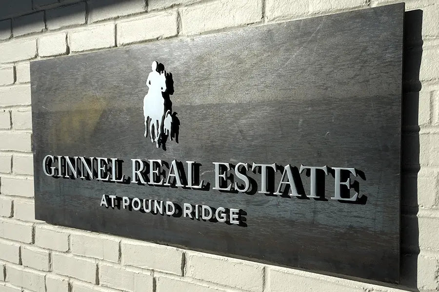 Residential development sign with stainless steel sign letters on a weathered steel plate.