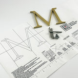 Brushed solid brass division 10 architectural sign letter on mounting template with hardware