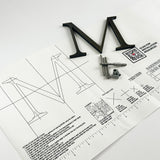 Heavily aged solid brass division 10 architectural sign letter on mounting template with hardware
