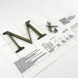 Aged solid brass division 10 architectural sign letter on mounting template with hardware