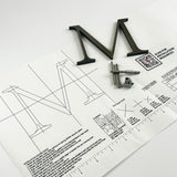 Aged solid brass division 10 architectural sign letter on mounting template with hardware