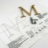 Vertically brushed solid bronze division 10 architectural sign letter on mounting template with hardware