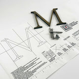 Lightly aged solid bronze division 10 architectural sign letter on mounting template with hardware