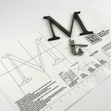 Aged solid bronze division 10 architectural sign letter on mounting template with hardware
