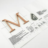 Orbitally brushed solid copper division 10 architectural sign letter on mounting template with hardware