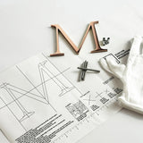 Polished solid copper division 10 architectural sign letter on mounting template with hardware