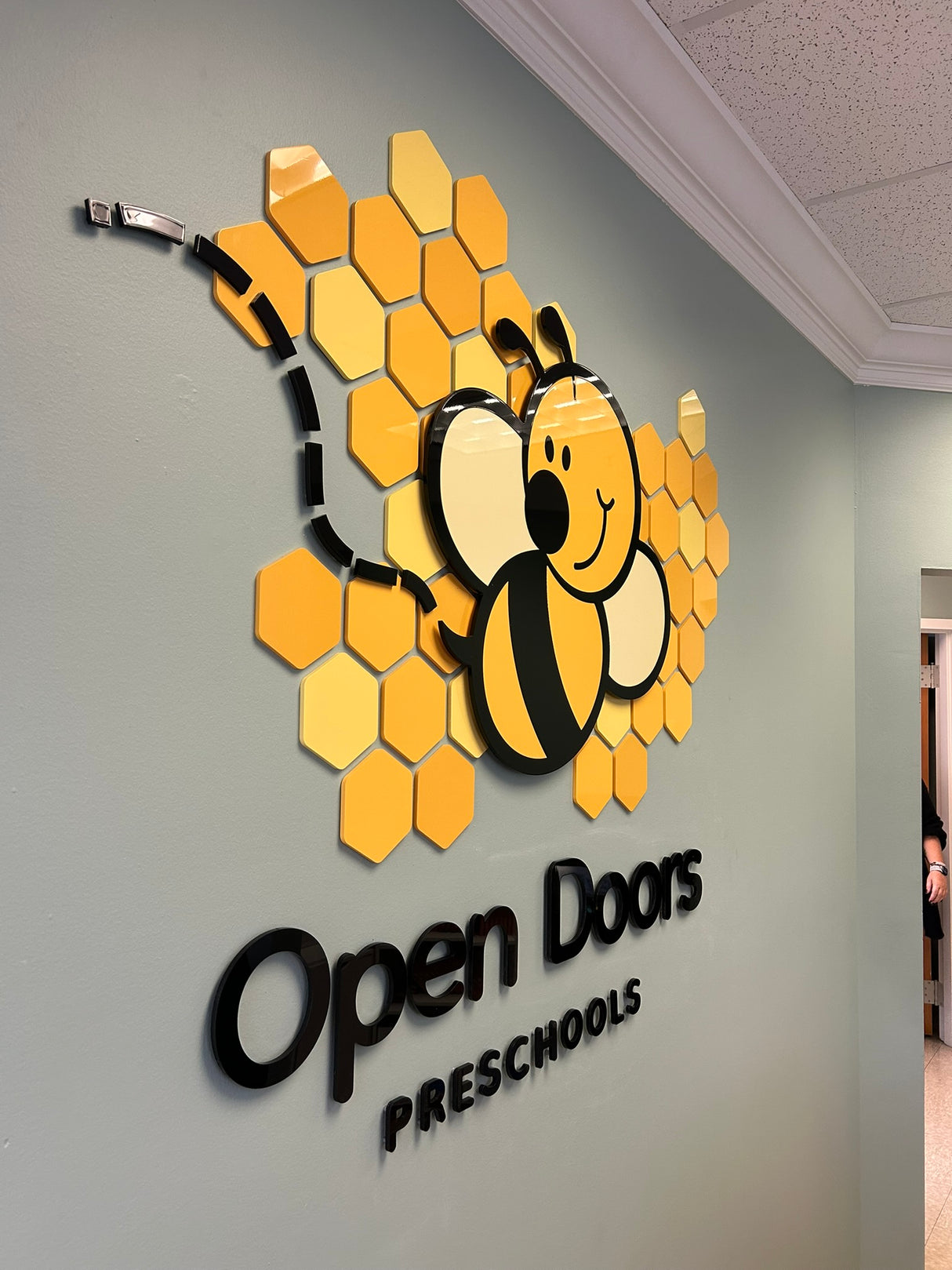 Flat cut acrylic preschool sign with black letters and a glossy sheen