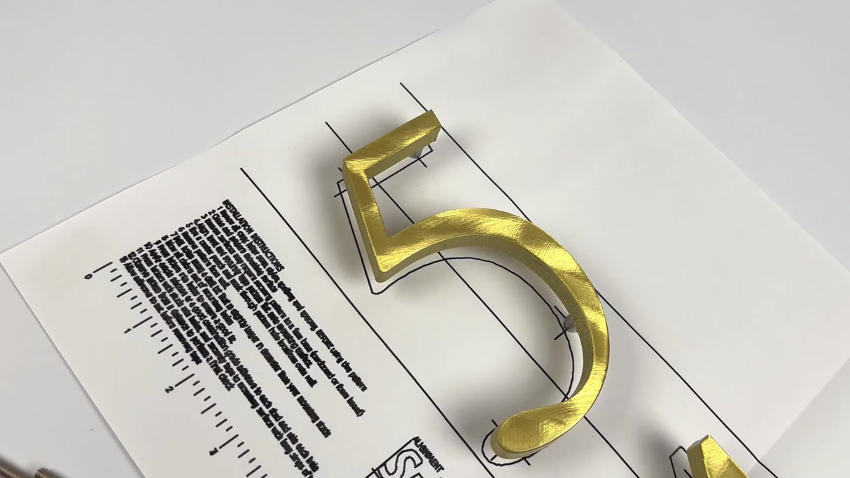 Random arch brushed solid brass division 10 architectural sign letters on a mounting template