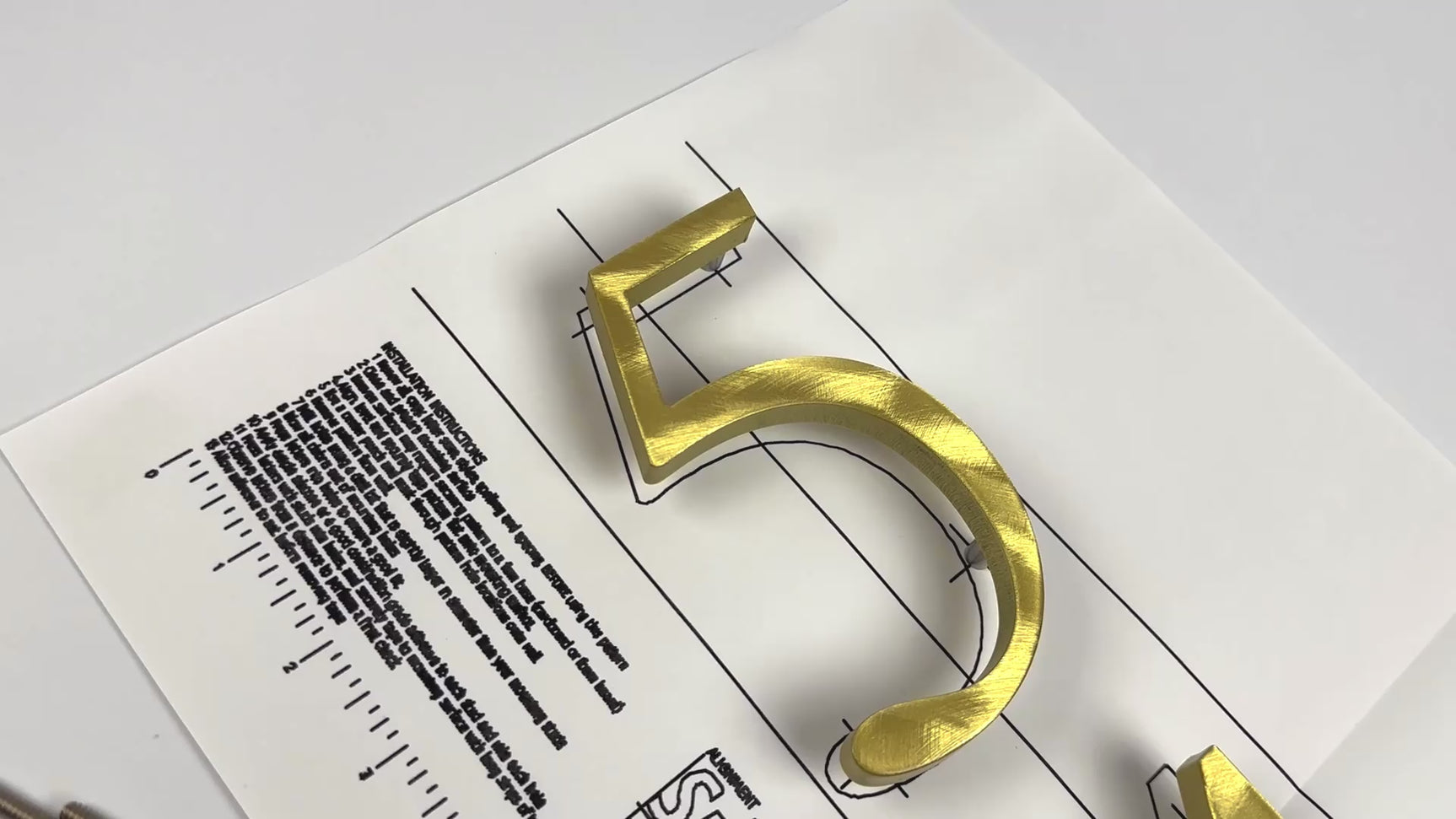 Random arch brushed solid brass division 10 architectural sign letters on a mounting template