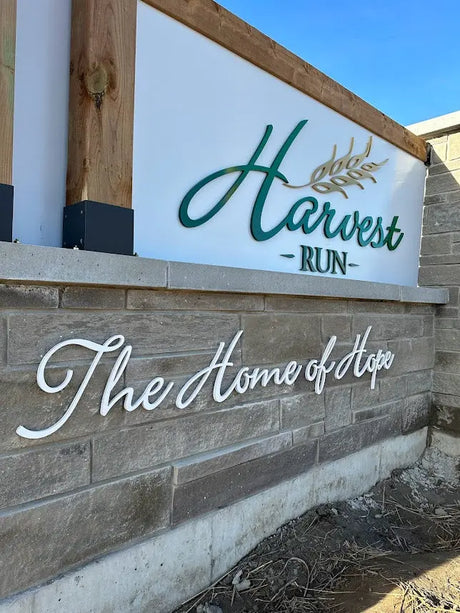 Monument sign with green and white painted aluminum sign letters